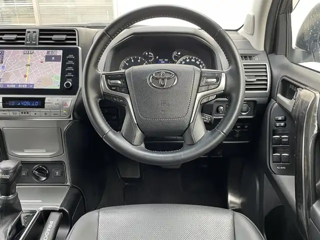 トヨタ ランドクルーザー プラド TX Lパッケージ 福岡県 2022(令4)年 2.6万km ホワイトパールクリスタルシャイン ワンオーナー/ルーフレール/ムーンルーフ/サイドステップ/全席黒レザーシート(合皮)/モデリスタエアロ【フロント・リア・マフラー】/TRDインナーステップガーニッシュ/インナードアハンドルカバー/純正９インチメモリナビ/【AM/FM/Bluetooth/USB/フルセグTV】/パノラミックビューモニター/ビルトインETC2.0/パワーシート(D/N席)/シートヒーター(D/N席)/エアーシート(D/N席)/トヨタセーフティセンス/・PCS(プリクラッシュセーフティ)/・LDA(レーンディパーチャーアラート)ヨーアシスト機能付き/・ふらつき警報機能/・車線逸脱警報機能/・車線逸脱抑制機能/・AHB(オートマチックハイビーム)/・RSA(ロードサインアシスト)/・レーダークルーズコントロール(全車速追従機能付き)/・先行車発進告知機能/BSM(ブラインドスポットモニター)/PKSB(パーキングサポートブレーキ)/ウィンドシールドデアイサー/社外デジタルインナーミラー型前後ドライブレコーダー(GPS付き)CELLSTAR【TZ-D203MW】/純正フロアマット/純正１５インチアルミホイール/スペアキー×１/ドアバイザー/取扱説明書/保証書