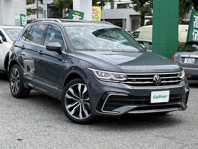 フォルクスワーゲン ティグアン TSI Rライン 東京都 2023(令5)年 0.7万km グレー ワンオーナー　/新車時保証書 取扱説明書　ナビ説明書/プリクラッシュブレーキシステム【歩行者検知】/リヤトラフィックアラート【後退時衝突軽減ブレーキ】/レーンチェンジアシスト/アダプティブクルーズコントロール/レーンキープアシスト/パーキングアシスト/アイドリングストップ/9.2インチ純正ナビ Discover Pro/フルセグTV/Apple CarPlay/Android Auto/Mirror Link/Harman/Kardon/アランドビューモニター　ETC【2.0】/デジタルコックピット/前後ドラレコ/電動サンシェード付ガラスルーフ/レザーシート/全席シートヒーター/D/N席メモリー付パワーシート/パドルシフト付きヒーター機能搭載革巻きハンドル/フロント・サイド・カーテン・ニーエアバッグ/LEDオートライト/オートハイビーム/スマートキー×2/純正20インチアルミ