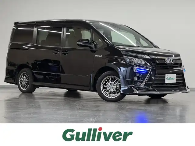 トヨタ ヴォクシー ハイブリッド ZS 三重県 2019(令1)年 3.1万km ブラック ハイブリッド/FF/インパネCVT/純正 9インチナビ NSZT-Y68T/（AM/FM/CD/DVD/TV/SD/SDREC/Bluetooth）/純正 12.1インチ 後席フリップダウンモニター V12T-R68C/バックガイドモニター/モデリスタカスタムパーツ/・エアロキット（F/S/R/Rアンダー）/・スポーツマフラー/・シグネチャーイルミブレード/両側パワースライドドア/ドライブレコーダー 前後/ビルトイン ETC2.0/Toyota Safety Sense/・プリクラッシュセーフティ［PCS］/・レーンディパーチャーアラート［LDA］/・オートハイビーム［AHB］/・インテリジェントクリアランスソナー（パーキングサポートブレーキ［PKSB］（静止物））/装備/・快適温熱シート（D/N）/・クルーズコントロール/・左右独立オートエアコン＋後席クーラー/・オートライト/・LED ヘッドランプ＋フロントフォグランプ/・ステアリングスイッチ/・純正16inAW/・保/取/ナビ取/・スマートキーx2