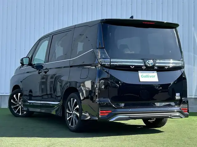 トヨタ ヴォクシー ハイブリッド S－Z 香川県 2022(令4)年 2.1万km アティチュードブラックマイカ モデリスタエアロ/純正１０．５型ＴＶ、ナビ付ＤＡ/バックカメラ/純正１４型EL有機後席モニター/トヨタセーフティセンス/・プリクラッシュセーフティ (PCS)/・レーントレーシングアシスト (LTA)/・レーダークルーズコントロール (ACC)/・オートマチックハイビーム (AHB)/・プロアクティブドライビングアシスト (PDA)/・発進遅れ告知機能/前後ドライブレコーダー/ビルトインＥＴＣ２．０/ハーフレザーシート/シートヒーター/スマートキー/スペアキー/純正17インチAW/純正フロアマット