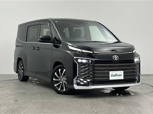トヨタ ヴォクシー S－Z 三重県 2022(令4)年 2.1万km アティチュードブラックマイカ 禁煙車/純正ディスプレイオーディオ/・Bluetooth・フルセグ・CD/DVD・USB・HDMI/両側パワースライドドア/トヨタセーフティセンス/・プリクラッシュセーフティシステム/・レーンディパーチャーアラート/・レーダークルーズコントロール/・クリアランスソナー/・リアトラフィックアラート/・アドバンスドドライブ/・パーキングアシスト/.ブラインドスポットモニター/デジタルインナーミラー/ヘッドアップディスプレイ/アラウンドビューモニター/パワーバックドア/全席シートヒーター/ステアリングヒーター/スマートキー/プッシュスタート/スペアキー/純正フロアマット/純正１７インチアルミホイール/ビルドインETC2.0