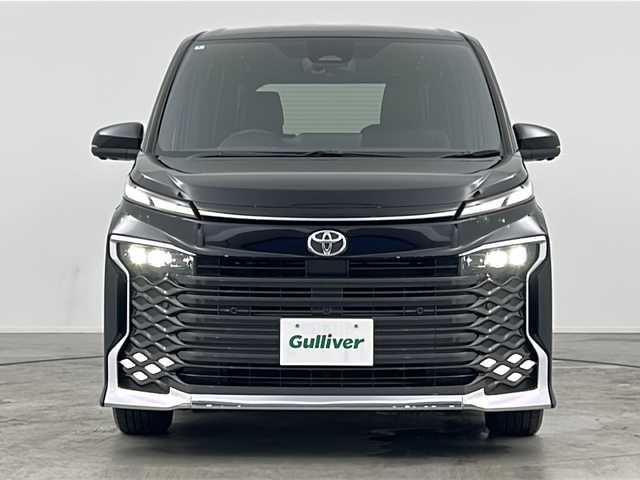 トヨタ ヴォクシー S－Z 三重県 2022(令4)年 2.1万km アティチュードブラックマイカ 禁煙車/純正ディスプレイオーディオ/・Bluetooth・フルセグ・CD/DVD・USB・HDMI/両側パワースライドドア/トヨタセーフティセンス/・プリクラッシュセーフティシステム/・レーンディパーチャーアラート/・レーダークルーズコントロール/・クリアランスソナー/・リアトラフィックアラート/・アドバンスドドライブ/・パーキングアシスト/.ブラインドスポットモニター/デジタルインナーミラー/ヘッドアップディスプレイ/アラウンドビューモニター/パワーバックドア/全席シートヒーター/ステアリングヒーター/スマートキー/プッシュスタート/スペアキー/純正フロアマット/純正１７インチアルミホイール/ビルドインETC2.0