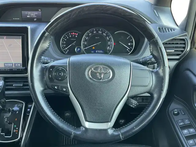 トヨタ エスクァイア Gi 道央・札幌 2015(平27)年 8.8万km スパークリングブラックパールクリスタルシャイン ４WD/寒冷地仕様/純正ディーラーOPナビ/CD/DVD/BT/フルセグ/純正フリップダウンモニター/横滑り防止装置/クルーズコントロール/バックカメラ/ビルトインETC/アイドリングストップ/ECOMODE/自動防眩ミラー/両側パワースライドドア/前席シートヒーター/レザーシート/革巻きウッドコンビステアリング/ステアリングリモコン/MTモード付AT/プッシュスタート/スマートキー/LEDヘッドライト/オートライト/オートハイビーム/フォグランプ/電動格納ミラー/ウィンカーミラー/純正フロアマット/ドアバイザー/スペアキー/純正エンジンスターター/純正AW付冬タイヤ積込/195/65/R15/2019年/山5mm/社外アルミホイール積込（４本）