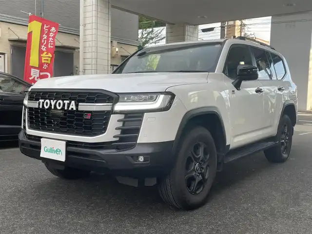 トヨタ ランドクルーザー GRスポーツ 愛知県 2024(令6)年 1.5万km プレシャスホワイトパール ワンオーナー/ムーンルーフ/ブラックルーフレール〈MOP〉/ブラックレザーシート/前席パワーシート/・マイコンプリセットドライビングポジションシステム/前席・2列目左右シートヒーター＆ベンチレーション/3列目電動格納シート/Tコネクトナビゲーションシステム〈MOP〉/・12.3インチディスプレイ/・地デジTV／DVD／Bluetooth／Miracast／USB/・マルチテレインモニター/・ドライブモードセレクト（CUSTOM）/JBLプレミアムサウンドシステム〈MOP〉/リアエンターテイメントシステム〈MOP〉/フロント／バック／アラウンドビューカメラ/パワーバックドア/電動デフロック/LEDヘッドライト／シーケンシャルターンランプ/クールボックス〈MOP〉/寒冷地仕様〈MOP〉/・LEDリアフォグ／デアイサー／カメラ洗浄機能/TOYOTA SAFETY SENSE/・プリクラッシセーフティ/・レーントレーシングアシスト/・レーダークルーズコントロール/・ロードサインアシスト/・アダプティブハイビーム/パーキングサポートブレーキ/ブラインドスポットモニター/充電用USBタイプC端子/純正18インチAW〈マットグレー塗装〉