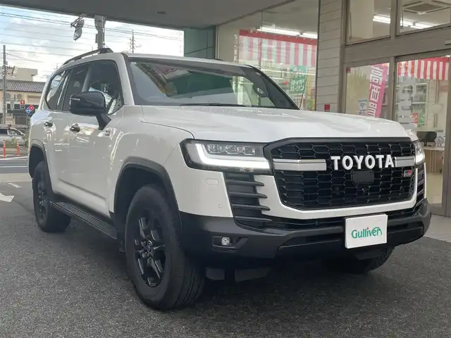 トヨタ ランドクルーザー GRスポーツ 愛知県 2024(令6)年 1.5万km プレシャスホワイトパール ワンオーナー/ムーンルーフ/ブラックルーフレール〈MOP〉/ブラックレザーシート/前席パワーシート/・マイコンプリセットドライビングポジションシステム/前席・2列目左右シートヒーター＆ベンチレーション/3列目電動格納シート/Tコネクトナビゲーションシステム〈MOP〉/・12.3インチディスプレイ/・地デジTV／DVD／Bluetooth／Miracast／USB/・マルチテレインモニター/・ドライブモードセレクト（CUSTOM）/JBLプレミアムサウンドシステム〈MOP〉/リアエンターテイメントシステム〈MOP〉/フロント／バック／アラウンドビューカメラ/パワーバックドア/電動デフロック/LEDヘッドライト／シーケンシャルターンランプ/クールボックス〈MOP〉/寒冷地仕様〈MOP〉/・LEDリアフォグ／デアイサー／カメラ洗浄機能/TOYOTA SAFETY SENSE/・プリクラッシセーフティ/・レーントレーシングアシスト/・レーダークルーズコントロール/・ロードサインアシスト/・アダプティブハイビーム/パーキングサポートブレーキ/ブラインドスポットモニター/充電用USBタイプC端子/純正18インチAW〈マットグレー塗装〉