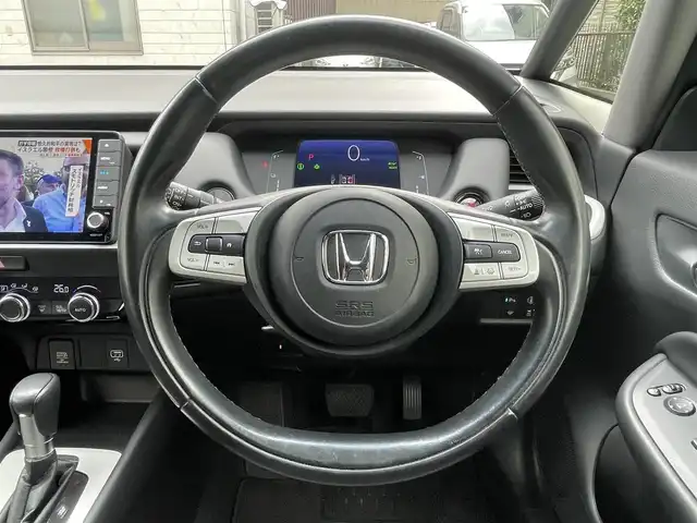 ホンダ フィット e:HEVホーム 埼玉県 2021(令3)年 7万km シャイニンググレーM 登録時69378km/純正９インチナビ（BT/フルセグ）/バックカメラ/衝突軽減ブレーキ/路外逸脱制御機能/踏み間違い衝突軽減システム/レーダークルーズコントロール/パーキングセンサー/前後ドライブレコーダー/プッシュスタート/スマートキー×２/ビルトインETC/ハーフレザーシート/革巻きハンドル/ステアリングリモコン/オートライト/純正LEDヘッドライト/ウインカーミラー/横滑り防止装置/フロアマット/スタットレスタイヤ４本積込/保証書/取扱説明書/ナビ取扱説明書