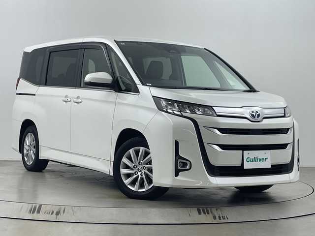 トヨタ ノア ハイブリッド Z 埼玉県 2022(令4)年 1.7万km ホワイトパールクリスタルシャイン 純正ナビ機能付ディスプレイオーディオ/(Bluetooth/HDMI/CD/DVD/USB/AM/FM)/地デジフルセグ/バックカメラ/ETC2.0/アダプティブクルーズコントロール/オートマチックハイビーム/車線逸脱警報/衝突軽減ブレーキ/クリアランスソナー/リヤシートリマインダー/オットマン/前席・2列目シートヒーター/AC100V/電子パーキングシステム/ブレーキホールド/ドライブモードセレクト/プッシュスタート/ステアリングリモコン/ウィンカー・電動格納ミラー/ロールサンシェード/フロントフォグランプ/純正フロアマット/純正ドアバイザー/純正16インチアルミホイール