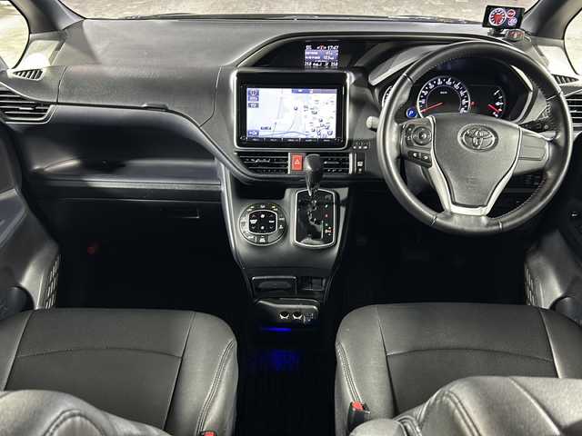 トヨタ ヴォクシー ZS 煌 沖縄県 2016(平28)年 9.2万km ブラッキッシュアゲハガラスフレーク 禁煙車/県外仕入れ/純正９インチナビ/【CD/DVD/フルセグTV/BT】/バックカメラ/１１インチ後席フリップダウンモニター/ETC/両側パワースライドドア/TRDフロントエアロ/トヨタセーフティセンス/→プリクラッシュセーフティ/→レーンディパーチャーアラート/→オートマチックハイビーム/USBポート/革調シートカバー/純正ヘッドライト/１８インチモデリスタアルミ/スマートキー