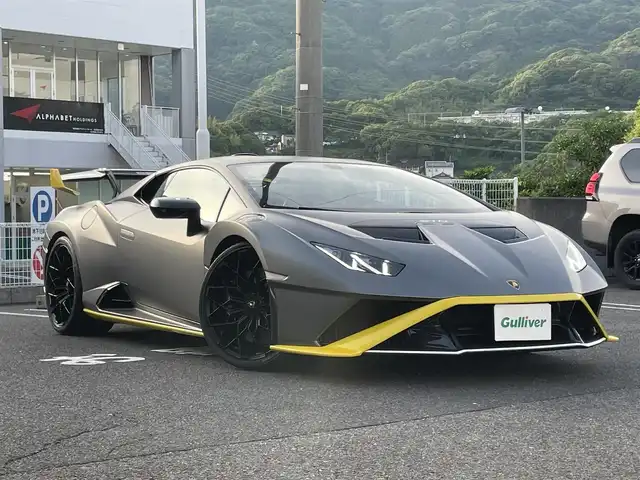 ランボルギーニ ウラカン EVO RWD 長崎県 2021(令3)年 1.4万km グレー ボディカラーGrigio Titans/純正ナビ（ＡＭ／ＦＭ／ＢＴ）/ドライブモードセレクト（ＳＴＯ／ＴＲＯＦＥＯ／ＰＩＯＧＧＩＡ）/パドルシフト/左ハンドル/ステアリングスイッチ/ＬＤＶＩ（統合制御装置）/エアサス/ポテンザタイヤ（２４５／３０／Ｒ２０）/デジタルインナーミラー型ドラレコ/バックカメラ/パワーステアリング/パワーウインドウ/ETC/USB端子×２/電格ミラー/スマートキー×２/アクアポビッチチタンマフラー/エクステリアフルカーボン/インテリアフルカーボン/フロントフルプロテクションフィルム/サイド下部プロテクションフィルム/リア下部プロテクションフィルム/純正ミラー有り/純正タイヤパンク修理キット/取説/保証書