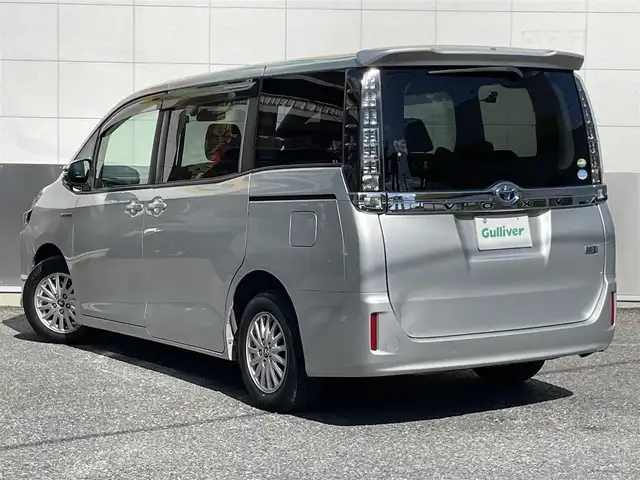 トヨタ ヴォクシー ハイブリッド X 東京都 2014(平26)年 10.7万km シルバーM ワンオーナー/社外メモリーナビ/　フルセグTV/DVD/CD/Bluetooth/バックカメラ/前後ドライブレコーダー/両側パワースライドドア/ビルトインETC/LEDヘッドライト/オートライト/電動格納ミラー/ウインカーミラー/プッシュスタート/スマートキー/純正フロアマット/ドアバイザー/保証書/取扱説明書