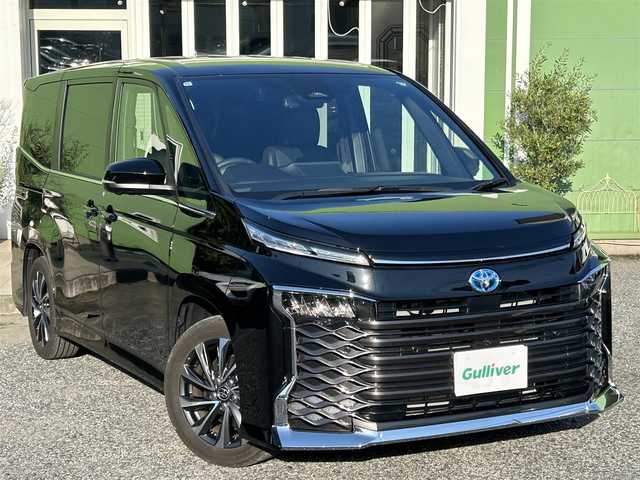 トヨタ ヴォクシー ハイブリッド S－Z 埼玉県 2024(令6)年 1万km アティチュードブラックマイカ ワンオーナー車/快適利便パッケージ/トヨタチームメイト＋PKSB/純正ナビTV/（DVD再生可能）/パノラミックビューモニター/ユニバーサルステップ/両側パワースライドドア/パワーバックドア/LEDヘッドライト/純正17インチアルミ/衝突軽減ブレーキ/レーダークルーズコントロール/クリアランスソナー/ステアリングヒーター/AC100V1500Wコンセント/プッシュスタート/スマートキー/保証書付整備手帳/取扱説明書