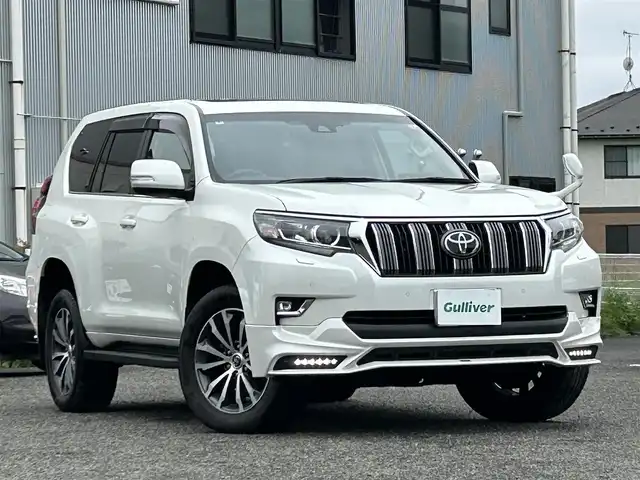 トヨタ ランドクルーザー プラド TX Lパッケージ 宮城県 2020(令2)年 6.5万km ホワイトパールクリスタルシャイン 装備/ベージュ内装/サンルーフ/ＴＲＤ前後エアロ/純正ナビ/(AM、FM、CD、DVD、フルセグTV、SD、BT、USB)/純正エンジンスターター×１/スペアキー×１/ＴＶキャンセラー/３列シート/ウッドステアリング/プッシュスタートボタン/ドアバイザー/機能/寒冷地仕様/レーダークルーズコントロール/レーンキープアシスト/シートヒーターD、N/シートクーラーD、N/パワーシートD、N/横滑り防止/2ndSTARTボタン/四駆切り替えボタン/オフロード切り替えボタン/リアフォグインジケーター/オートライト/アイドルアップ