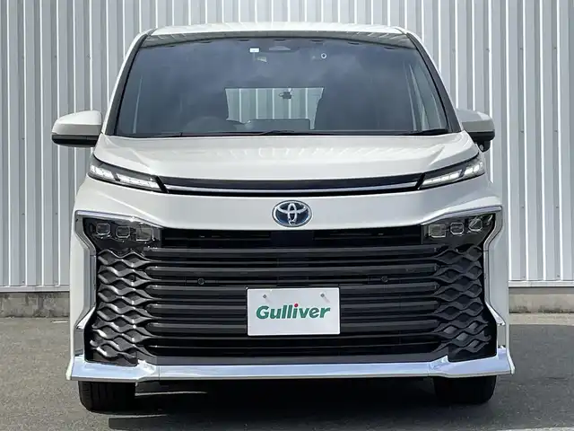 トヨタ ヴォクシー ハイブリッド S－Z 福岡県 2023(令5)年 1.3万km ホワイトパールクリスタルシャイン １０インチディスプレイオーディオプラス　/快適利便パッケージ　/ＬＤＡ　/ＢＳＭ　/ＰＣＳ　/クリアランスソナー　/両側電動ドア　/前席シートヒーター　/ステアリングヒーター　/オットマン　/パワーバックドア　/Ｂカメラ