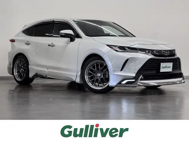トヨタ ハリアー Z レザーパッケージ 三重県 2023(令5)年 2.3万km プラチナホワイトパールマイカ ガソリン/FF/MTモード付フロアCVT/純正12.3インチナビ/（AM/FM/TV/Bluetooth/USB/iPod/CarPlay/AndroidAuto/Miracast）/【OP】パノラミックビューモニター（床下透過表示機能付）/モデリスタエアロ（F/S/R下）/JBLプレミアムサウンドシステム（9スピーカー＆アンプ）/ドライブレコーダー 前後/ETC2.0/Toyota Safety Sense/●プリクラッシュセーフティ/●レーントレーシングアシスト/●レーダークルコン/●アダプティブハイビーム/●ロードサインアシスト/・ドライバー異常時対応システム/・発進遅れ告知/・ブラインドスポットモニター/・パーキングサポートブレーキ（前後静止物、後方接近車両）/など/装備/・デジタルインナーミラー（前後録画機能付）/・カラーHUD/・ハンズフリーパワーバックドア/・本革シート（黒）/・冷暖シート（D/N）/・ステアリングヒーター/・パワーシート（Dメモリー付8way（4wayランバーサポート付）/N4way）/・オートワイパー/・WORKアルミホイール『LANVEC LM7』20in×9J＋35/・TEIN 全調式車高調『FLEX Z』/・ガナドール 4本出しマフラー GVE-048MPO/など