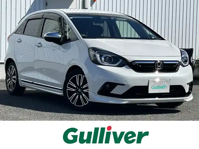 ホンダ フィット e:HEVリュクス 熊本県 2020(令2)年 11.3万km プラチナホワイトパール 純正ナビ/・AM/FM/CD/DVD/SD/AUX/iPod/USB/BT/・フルセグTV/バックカメラ/ホンダセンシング/・路外逸脱抑制機能/・踏み間違い衝突軽減システム/・衝突軽減ブレーキ/・パーキングセンサーシステム/・オートマチックハイビーム/・アダプティブクルーズコントロール/前後コーナーセンサー/革巻きステアリング/・ステアリングリモコン/レザーシート/・D/N席シートヒーター/オートライト/・LEDライト/・フォグランプ/電動格納ミラー/・ウィンカーミラー/純正ドライブレコーダー（前後）/ビルトインETC/電動サイドブレーキ/・ホールドボタン/トノカバー/純正フロアマット/純正アルミホイール/スマートキー/・スペアキー