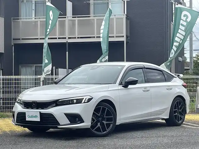 ホンダ シビック e:HEV 宮城県 2024(令6)年 1.5万km プラチナホワイトパール 純正リアスポイラー/純正ディスプレイオーディオナビ/フルセグＴＶ/BT/USB/AM/FM/スマートフォン連携/ホンダセンシング/・衝突軽減ブレーキ（CMBS）/・踏み間違い衝突軽減システム/・路外逸脱抑制機能/・歩行者事故低減ステアリング/・先行車発信お知らせ機能/・標識認識機能/・アダプティブドライビングビーム/・ブラインドスポットインフォメーション/・後退出庫サポート/・パーキングセンサーシステム/・ドライバー注意力モニター/・車線維持支援システム（LKAS）/ハーフレザーシート/D/N席パワーシート/シートヒーター/ワイヤレス充電/純正ドライブレコーダー（前後）/ビルトインＥＴＣ2.0/パドルシフト/電動パーキングブレーキ/オートブレーキホールド/カーテンエアバッグ/プッシュスタート/スマートキー×2/保証書/取扱説明書