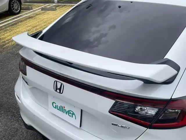 ホンダ シビック e:HEV 宮城県 2024(令6)年 1.5万km プラチナホワイトパール 純正リアスポイラー/純正ディスプレイオーディオナビ/フルセグＴＶ/BT/USB/AM/FM/スマートフォン連携/ホンダセンシング/・衝突軽減ブレーキ（CMBS）/・踏み間違い衝突軽減システム/・路外逸脱抑制機能/・歩行者事故低減ステアリング/・先行車発信お知らせ機能/・標識認識機能/・アダプティブドライビングビーム/・ブラインドスポットインフォメーション/・後退出庫サポート/・パーキングセンサーシステム/・ドライバー注意力モニター/・車線維持支援システム（LKAS）/ハーフレザーシート/D/N席パワーシート/シートヒーター/ワイヤレス充電/純正ドライブレコーダー（前後）/ビルトインＥＴＣ2.0/パドルシフト/電動パーキングブレーキ/オートブレーキホールド/カーテンエアバッグ/プッシュスタート/スマートキー×2/保証書/取扱説明書