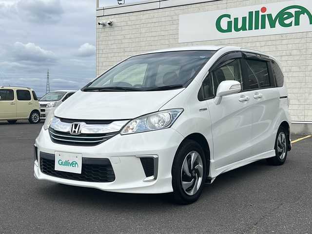 ホンダ フリード ハイブリット ジャストセレクション 香川県 2014(平26)年 7.3万km ホワイトオーキッドパール 純正ナビ/ワンセグテレビ/CD/DVD機能/バックカメラ/3列シート/両側パワースライドドア/ＨＩＤヘッドライト/オートライト/ETC/スペアキー
