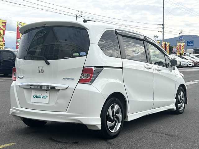 ホンダ フリード ハイブリット ジャストセレクション 香川県 2014(平26)年 7.3万km ホワイトオーキッドパール 純正ナビ/ワンセグテレビ/CD/DVD機能/バックカメラ/3列シート/両側パワースライドドア/ＨＩＤヘッドライト/オートライト/ETC/スペアキー