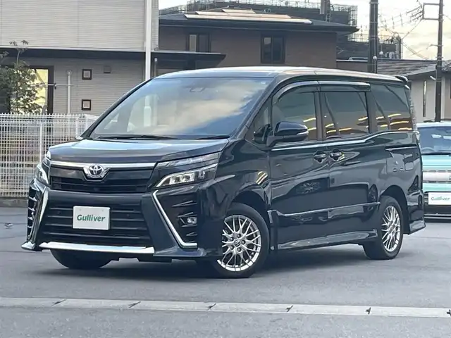 トヨタ ヴォクシー ハイブリッド ZS 静岡県 2021(令3)年 4.3万km ブラッキッシュアゲハガラスフレーク エンジンスタートボタン/パワーステアリング/パワーウィンドウ/アイドリングストップ/Ｗオートエアコン/スマートキー/スペアキー1本/クルーズコントロール/純正12.1インチ後席モニター/USB入力端子/ETC/バックカメラ/純正10インチナビ（CD/DVD/BT/フルセグ）/三列シート/ウォークスルー/ドライブレコーダー前後/純正フロアマット/両側パワースライドドア/布シート/前席シートヒーター/アルミホイール/ABS/横滑り防止装置/コーナーセンサー前後/レーンキープアシスト/オートライト/オートマチックハイビーム/LEDヘッドライト/Wエアバッグ/衝突軽減システム/HDMI