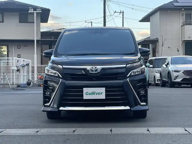 トヨタ ヴォクシー ハイブリッド ZS 静岡県 2021(令3)年 4.3万km ブラッキッシュアゲハガラスフレーク エンジンスタートボタン/パワーステアリング/パワーウィンドウ/アイドリングストップ/Ｗオートエアコン/スマートキー/スペアキー1本/クルーズコントロール/純正12.1インチ後席モニター/USB入力端子/ETC/バックカメラ/純正10インチナビ（CD/DVD/BT/フルセグ）/三列シート/ウォークスルー/ドライブレコーダー前後/純正フロアマット/両側パワースライドドア/布シート/前席シートヒーター/アルミホイール/ABS/横滑り防止装置/コーナーセンサー前後/レーンキープアシスト/オートライト/オートマチックハイビーム/LEDヘッドライト/Wエアバッグ/衝突軽減システム/HDMI