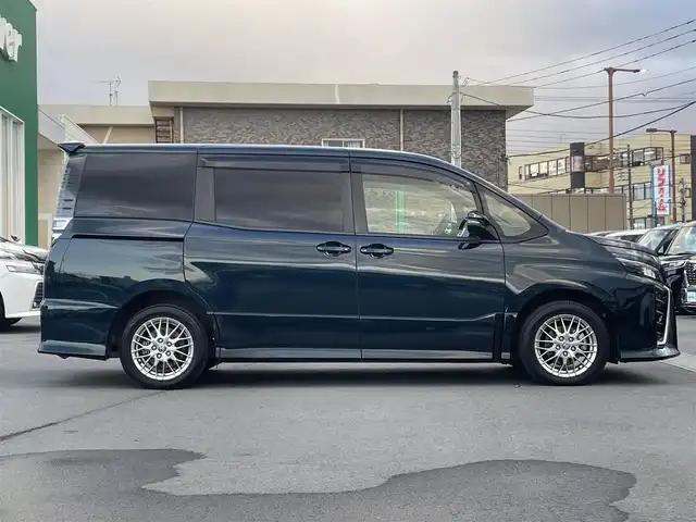 トヨタ ヴォクシー ハイブリッド ZS 静岡県 2021(令3)年 4.3万km ブラッキッシュアゲハガラスフレーク エンジンスタートボタン/パワーステアリング/パワーウィンドウ/アイドリングストップ/Ｗオートエアコン/スマートキー/スペアキー1本/クルーズコントロール/純正12.1インチ後席モニター/USB入力端子/ETC/バックカメラ/純正10インチナビ（CD/DVD/BT/フルセグ）/三列シート/ウォークスルー/ドライブレコーダー前後/純正フロアマット/両側パワースライドドア/布シート/前席シートヒーター/アルミホイール/ABS/横滑り防止装置/コーナーセンサー前後/レーンキープアシスト/オートライト/オートマチックハイビーム/LEDヘッドライト/Wエアバッグ/衝突軽減システム/HDMI