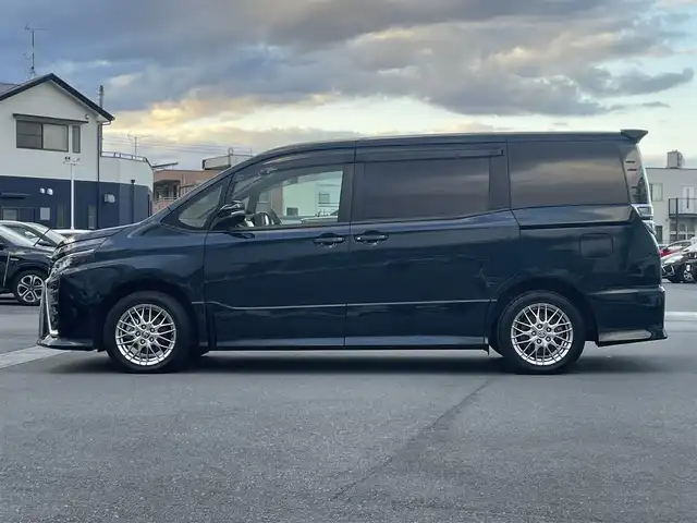 トヨタ ヴォクシー ハイブリッド ZS 静岡県 2021(令3)年 4.3万km ブラッキッシュアゲハガラスフレーク エンジンスタートボタン/パワーステアリング/パワーウィンドウ/アイドリングストップ/Ｗオートエアコン/スマートキー/スペアキー1本/クルーズコントロール/純正12.1インチ後席モニター/USB入力端子/ETC/バックカメラ/純正10インチナビ（CD/DVD/BT/フルセグ）/三列シート/ウォークスルー/ドライブレコーダー前後/純正フロアマット/両側パワースライドドア/布シート/前席シートヒーター/アルミホイール/ABS/横滑り防止装置/コーナーセンサー前後/レーンキープアシスト/オートライト/オートマチックハイビーム/LEDヘッドライト/Wエアバッグ/衝突軽減システム/HDMI