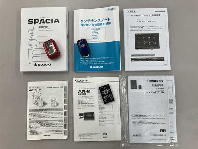 スズキ スペーシア ギア HYBRID XZターボ 埼玉県 2025(令7)年 0.3万km オフブルーメタリック/ガンメタリック2トーンルーフ ワンオーナー/衝突被害軽減ブレーキ/レーダークルーズコントロール/前後コーナーセンサー/バックカメラ/純正ナビ・オーディオ/Panasonic：CN-HZ8A5/（フルセグTV/BT/CD/DVD/FM/AM）/前後ドラレコ/レーダー探知機/ヘッドアップディスプレイ/両側パワースライドドア/ビルトンETC/前席シートヒーター/ステアリングヒーター/ステアリングリモコン/パドルシフト/革巻きステアリング/後席オットマン/後席サンシェード/ヘッドアップディスプレイ/USBポート×4/フォグライト/スマートキー（スペアキーあり）/車両取説、ナビ取説、メンテナンスノートあり/プッシュスタート/アイドリングストップ