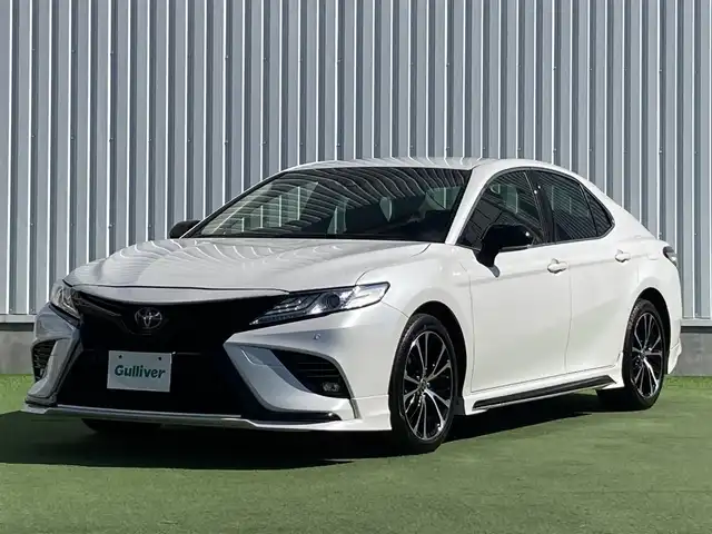 トヨタ カムリ WSレザーパッケージ 香川県 2020(令2)年 8.3万km プラチナホワイトパールマイカ 登録時走行距離：82489km/TRDエアロ/→フロントスポイラー/→サイドスカート/→リヤバンパースポイラー/トヨタセーフティーセンス/→プリクラッシュセーフティ/→レーンディパーチャーアラート/→レーダークルーズコントロール/→クリアランスソナー/→ヘッドアップディスプレイ/純正9インチディスプレイオーディオ/→ナビ機能あり/→フルセグTV・BT/ブラックレザーシート/シートヒーター/パワーシート/革巻きステアリング/ステアリングリモコン/パドルシフト/MTモード付AT/ホールド機能付き電子パーキングブレーキ/LEDヘッドライト/LEDフォグライト/純正18インチAW/スマートキー/プッシュスタート