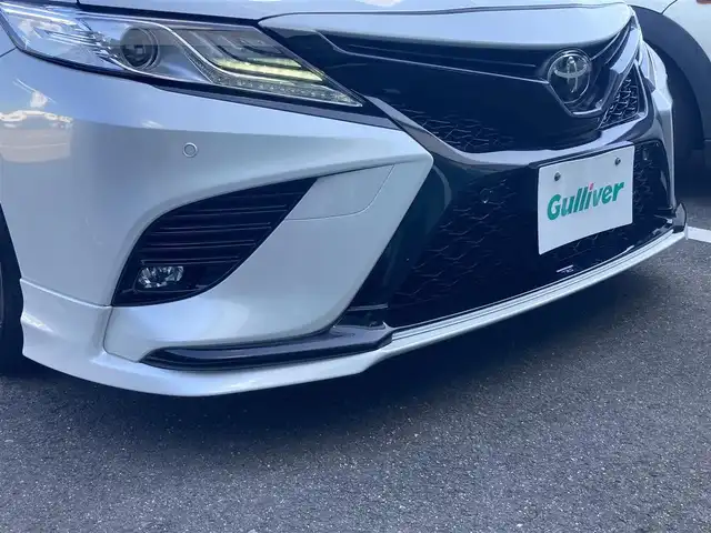 トヨタ カムリ WSレザーパッケージ 香川県 2020(令2)年 8.3万km プラチナホワイトパールマイカ 登録時走行距離：82489km/TRDエアロ/→フロントスポイラー/→サイドスカート/→リヤバンパースポイラー/トヨタセーフティーセンス/→プリクラッシュセーフティ/→レーンディパーチャーアラート/→レーダークルーズコントロール/→クリアランスソナー/→ヘッドアップディスプレイ/純正9インチディスプレイオーディオ/→ナビ機能あり/→フルセグTV・BT/ブラックレザーシート/シートヒーター/パワーシート/革巻きステアリング/ステアリングリモコン/パドルシフト/MTモード付AT/ホールド機能付き電子パーキングブレーキ/LEDヘッドライト/LEDフォグライト/純正18インチAW/スマートキー/プッシュスタート