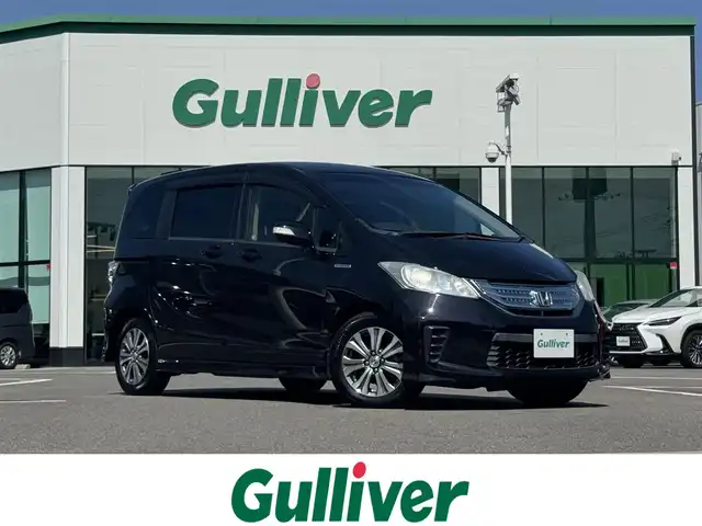 ホンダ フリード ハイブリット ジャストセレクション 愛媛県 2013(平25)年 8.4万km プレミアムブラキッシュパール 登録時走行距離：83666Km/純正HDDナビ/AM/FM/ワンセグTV/ＤＶＤ/ETC/ＡＡＣ/Bカメラ/クルーズコントロール/両側パワスラ/横滑り防止装置/盗難防止装置/ハーフレザーシート/キセノンヘッドライト/オートライト/リモコンキー/スペアキー1本/純正アルミホイール/純正フロアマット