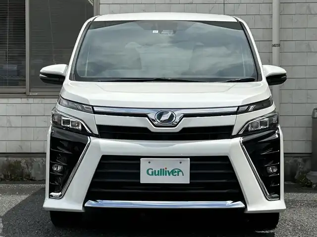 トヨタ ヴォクシー ハイブリッド ZS 福岡県 2017(平29)年 9.3万km ホワイトパールクリスタルシャイン ワンオーナー/エアロ（サイド）/純正10インチメモリナビ【NSZN-Z66T】/　（AM/FM/HDMI/Bluetooth/フルセグTV）/バックカメラ/純正12インチフリップダウンモニター　リモコン付き【V12T-R66C】/トヨタセーフティーセンス/・プリクラッシュセーフティー/・レーントレーシングサポート/・レーンディパーチャーアラート/・クルーズコントロール/・オートマチックハイビーム/・車両接近通報装置/・横滑り防止装置/・先行者発進アラーム/両側パワースライドドア/純正16インチアルミホイール/シートヒーター/黒色レザー調シートカバー/ビルトインETC/オートライト/フロントフォグランプ/盗難防止装置/電格ミラー/ドアバイザー/プッシュスタート/純正フロアマット/ISOFIX/2.1A電源プラグ×2/スペアキー×1/保証書/取扱説明書/ナビ取扱説明書