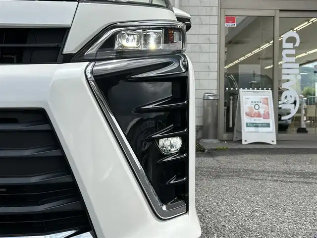 トヨタ ヴォクシー ハイブリッド ZS 福岡県 2017(平29)年 9.3万km ホワイトパールクリスタルシャイン ワンオーナー/エアロ（サイド）/純正10インチメモリナビ【NSZN-Z66T】/　（AM/FM/HDMI/Bluetooth/フルセグTV）/バックカメラ/純正12インチフリップダウンモニター　リモコン付き【V12T-R66C】/トヨタセーフティーセンス/・プリクラッシュセーフティー/・レーントレーシングサポート/・レーンディパーチャーアラート/・クルーズコントロール/・オートマチックハイビーム/・車両接近通報装置/・横滑り防止装置/・先行者発進アラーム/両側パワースライドドア/純正16インチアルミホイール/シートヒーター/黒色レザー調シートカバー/ビルトインETC/オートライト/フロントフォグランプ/盗難防止装置/電格ミラー/ドアバイザー/プッシュスタート/純正フロアマット/ISOFIX/2.1A電源プラグ×2/スペアキー×1/保証書/取扱説明書/ナビ取扱説明書