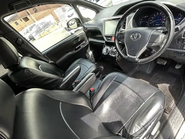 トヨタ ヴォクシー ハイブリッド ZS 福岡県 2017(平29)年 9.3万km ホワイトパールクリスタルシャイン ワンオーナー/エアロ（サイド）/純正10インチメモリナビ【NSZN-Z66T】/　（AM/FM/HDMI/Bluetooth/フルセグTV）/バックカメラ/純正12インチフリップダウンモニター　リモコン付き【V12T-R66C】/トヨタセーフティーセンス/・プリクラッシュセーフティー/・レーントレーシングサポート/・レーンディパーチャーアラート/・クルーズコントロール/・オートマチックハイビーム/・車両接近通報装置/・横滑り防止装置/・先行者発進アラーム/両側パワースライドドア/純正16インチアルミホイール/シートヒーター/黒色レザー調シートカバー/ビルトインETC/オートライト/フロントフォグランプ/盗難防止装置/電格ミラー/ドアバイザー/プッシュスタート/純正フロアマット/ISOFIX/2.1A電源プラグ×2/スペアキー×1/保証書/取扱説明書/ナビ取扱説明書