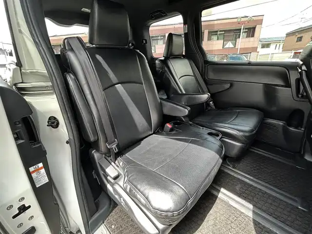 トヨタ ヴォクシー ハイブリッド ZS 福岡県 2017(平29)年 9.3万km ホワイトパールクリスタルシャイン ワンオーナー/エアロ（サイド）/純正10インチメモリナビ【NSZN-Z66T】/　（AM/FM/HDMI/Bluetooth/フルセグTV）/バックカメラ/純正12インチフリップダウンモニター　リモコン付き【V12T-R66C】/トヨタセーフティーセンス/・プリクラッシュセーフティー/・レーントレーシングサポート/・レーンディパーチャーアラート/・クルーズコントロール/・オートマチックハイビーム/・車両接近通報装置/・横滑り防止装置/・先行者発進アラーム/両側パワースライドドア/純正16インチアルミホイール/シートヒーター/黒色レザー調シートカバー/ビルトインETC/オートライト/フロントフォグランプ/盗難防止装置/電格ミラー/ドアバイザー/プッシュスタート/純正フロアマット/ISOFIX/2.1A電源プラグ×2/スペアキー×1/保証書/取扱説明書/ナビ取扱説明書