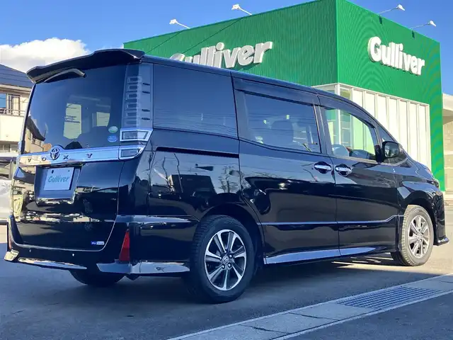 トヨタ ヴォクシー ZS 煌Ⅱ 静岡県 2019(令1)年 4.8万km ブラック エンジンスタートボタン/パワーステアリング/パワーウィンドウ/アイドリングストップ/スマートキー/スペアキー1本/WAC/レーダークルーズコントロール/ETC/バックカメラ/純正ナビ（CD/DVD/BT/フルセグ）/地図SDなし/三列シート/ドライブレコーダー/ウォークスルー/純正フロアマット/布シート/両側パワースライドドア/純正アルミホイール/ABS/横滑り防止装置/コーナーセンサー前後/レーンキープアシスト/オートライト/オートマチックハイビーム/LEDヘッドライト/Wエアバッグ/衝突軽減システム