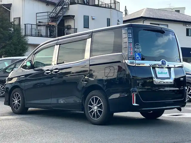 トヨタ ヴォクシー ハイブリッド V 静岡県 2014(平26)年 11.8万km ブラック エンジンスタートボタン/パワーステアリング/パワーウィンドウ/アイドリングストップ/スマートキー/Wオートエアコン/クルーズコントロール/ALPINE製11インチナビ（CD/DVD/BT/フルセグ）/ALPINE製10.2インチ後席モニター/バックカメラ/フロアマット/三列シート/ウォークスルー/D席N席シートヒーター/布シート/両側パワースライドドア/社外アルミホイール/ABS/オートライト/W+サイドエアバッグ/カーテンエアバッグ/衝突軽減システム