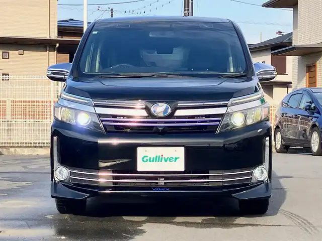 トヨタ ヴォクシー ハイブリッド V 静岡県 2014(平26)年 11.8万km ブラック エンジンスタートボタン/パワーステアリング/パワーウィンドウ/アイドリングストップ/スマートキー/Wオートエアコン/クルーズコントロール/ALPINE製11インチナビ（CD/DVD/BT/フルセグ）/ALPINE製10.2インチ後席モニター/バックカメラ/フロアマット/三列シート/ウォークスルー/D席N席シートヒーター/布シート/両側パワースライドドア/社外アルミホイール/ABS/オートライト/W+サイドエアバッグ/カーテンエアバッグ/衝突軽減システム