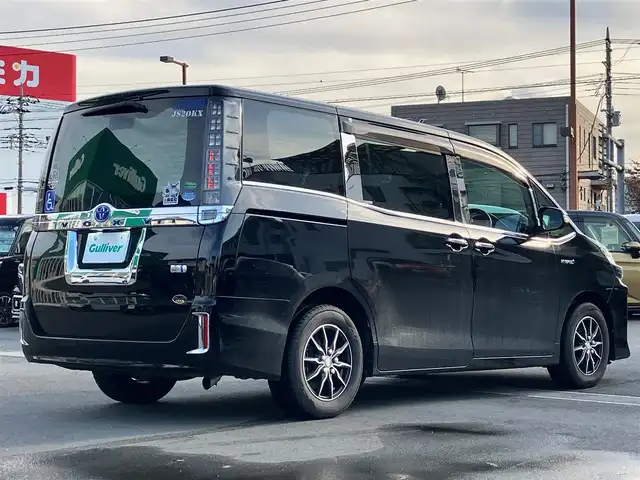 トヨタ ヴォクシー ハイブリッド V 静岡県 2014(平26)年 11.8万km ブラック エンジンスタートボタン/パワーステアリング/パワーウィンドウ/アイドリングストップ/スマートキー/Wオートエアコン/クルーズコントロール/ALPINE製11インチナビ（CD/DVD/BT/フルセグ）/ALPINE製10.2インチ後席モニター/バックカメラ/フロアマット/三列シート/ウォークスルー/D席N席シートヒーター/布シート/両側パワースライドドア/社外アルミホイール/ABS/オートライト/W+サイドエアバッグ/カーテンエアバッグ/衝突軽減システム