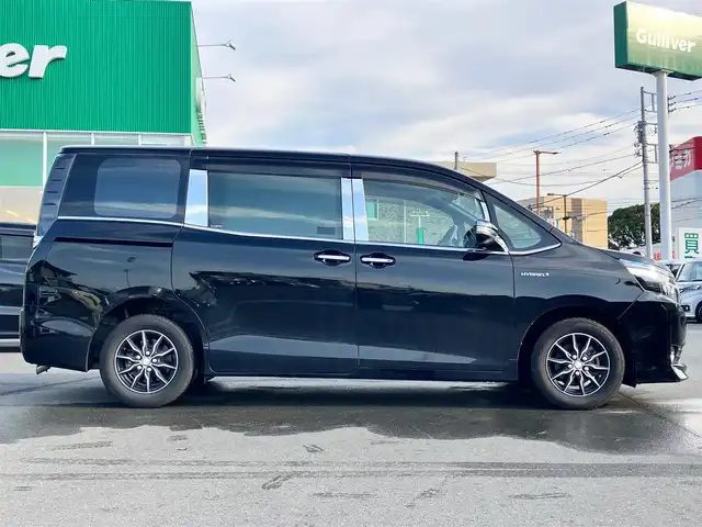 トヨタ ヴォクシー ハイブリッド V 静岡県 2014(平26)年 11.8万km ブラック エンジンスタートボタン/パワーステアリング/パワーウィンドウ/アイドリングストップ/スマートキー/Wオートエアコン/クルーズコントロール/ALPINE製11インチナビ（CD/DVD/BT/フルセグ）/ALPINE製10.2インチ後席モニター/バックカメラ/フロアマット/三列シート/ウォークスルー/D席N席シートヒーター/布シート/両側パワースライドドア/社外アルミホイール/ABS/オートライト/W+サイドエアバッグ/カーテンエアバッグ/衝突軽減システム