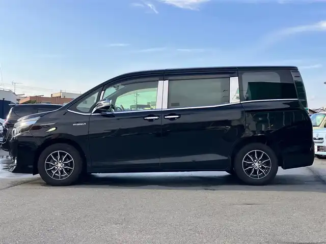 トヨタ ヴォクシー ハイブリッド V 静岡県 2014(平26)年 11.8万km ブラック エンジンスタートボタン/パワーステアリング/パワーウィンドウ/アイドリングストップ/スマートキー/Wオートエアコン/クルーズコントロール/ALPINE製11インチナビ（CD/DVD/BT/フルセグ）/ALPINE製10.2インチ後席モニター/バックカメラ/フロアマット/三列シート/ウォークスルー/D席N席シートヒーター/布シート/両側パワースライドドア/社外アルミホイール/ABS/オートライト/W+サイドエアバッグ/カーテンエアバッグ/衝突軽減システム