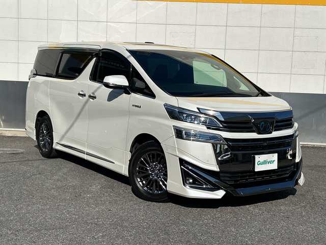 トヨタ ヴェルファイア ハイブリット エグゼクティブ ラウンジ 東京都 2018(平30)年 5.7万km ホワイトパールクリスタルシャイン モデリスタフルエアロ/ツインムーンルーフ/純正SDナビ/　Bluetooth/フルセグTV/DVD/CD/Blu-ray/HDMI/純正フリップダウンモニター/JBLプレミアムサウンドシステム/両側パワースライドドア/ビルトインETC2.0/レーダークルーズコントロール/パノラミックビューモニター/デジタルインナーミラー/プリクラッシュセーフティ/レーントレーシングアシスト/ロードサインアシスト/アダプティブハイビームシステム/レザーシート/パワーシート/シートヒーター/シートクーラー/インテリジェントクリアランスソナー/ブラインドスポットモニター/デジタルインナーミラー/パワーバックドア/3眼LEDヘットライト/LEDフォグランプ/LEDコーナリングランプ/シーケンシャルターンランプ/純正17インチアルミホイール/ステアリングヒーター/ステアリングスイッチ/置くだけ充電/AC100V電源/スペアキー×3/後席サンシェード/プッシュスタート/スマートキー/電動オート格納ミラー/ウインカーミラー/フロアマット/ドアバイザー/保証書/取扱説明書