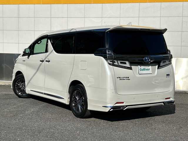 トヨタ ヴェルファイア ハイブリット エグゼクティブ ラウンジ 東京都 2018(平30)年 5.7万km ホワイトパールクリスタルシャイン モデリスタフルエアロ/ツインムーンルーフ/純正SDナビ/　Bluetooth/フルセグTV/DVD/CD/Blu-ray/HDMI/純正フリップダウンモニター/JBLプレミアムサウンドシステム/両側パワースライドドア/ビルトインETC2.0/レーダークルーズコントロール/パノラミックビューモニター/デジタルインナーミラー/プリクラッシュセーフティ/レーントレーシングアシスト/ロードサインアシスト/アダプティブハイビームシステム/レザーシート/パワーシート/シートヒーター/シートクーラー/インテリジェントクリアランスソナー/ブラインドスポットモニター/デジタルインナーミラー/パワーバックドア/3眼LEDヘットライト/LEDフォグランプ/LEDコーナリングランプ/シーケンシャルターンランプ/純正17インチアルミホイール/ステアリングヒーター/ステアリングスイッチ/置くだけ充電/AC100V電源/スペアキー×3/後席サンシェード/プッシュスタート/スマートキー/電動オート格納ミラー/ウインカーミラー/フロアマット/ドアバイザー/保証書/取扱説明書