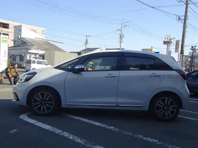 ホンダ フィット e:HEVリュクス 静岡県 2020(令2)年 2.8万km プレミアムサンライトホワイトパール 禁煙車/Gathers SDナビ/（CD/DVD/BT/USB/SD/フルセグTV)/ステアリングリモコン/バックカメラ/ステアリングヒーター/プレミアムライトブラウンインテリア/・ライトブラウンキルティングパーフォレーション革シート/・ライトブラウンプライムスムース（合皮）貼インパネ加飾/・革巻きステアリングホイール（ツートン）/運転席・助手席シートヒーター/ユピテル前方ドライブレコーダー/ASSURAレーダー/ETC/充電用USBジャック/ワイヤレス充電器/ホンダセンシング/・衝突軽減ブレーキ/・誤発進抑制機能/・近距離衝突軽減ブレーキ/・歩行者事故低減ステアリング/・路外逸脱抑制機能/・アダプティブクルーズコントロール/・車線維持支援システム/・トラフィックジャムアシスト/・先行車発進お知らせ機能/・標識認識機能/・オートハイビーム/・パーキングセンサーシステム/センターコンソール/プッシュスタート・スペアキー/スペアキー/保証書・取扱説明書