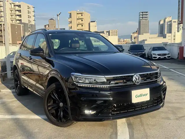 フォルクスワーゲン ティグアン TDI 4モーション Rライン ブラックスタイル 広島県 2018(平30)年 5.8万km ディープブラックパールエフェクト 走行距離57571km（入庫時）/450台限定特別仕様車/新車ワンオーナー/LEDヘッドランプ/純正19インチ5本ツインスポークブラック塗装アルミホイール/「R」ロゴ入チタンブラック革シート/運転席パワーシート/運転席&助手席トップコンフォートシート/運転席&助手席&後席シートヒーター/「R」エンブレム付革巻きスポーツステアリングホイール/アクティブインフォディスプレイ（12.3インチ液晶メーター）/ヘッドアップディスプレイ/パワーバックドア/DiscoverProナビゲーションシステム/・SSDナビゲーションシステム/・9インチタッチスクリーン/・フルセグテレビ/・CD&DVD再生可/・ETC2.0/リアビュー&アラウンドビューカメラ/オールインセーフティ（予防安全装備）/・アクティブクルーズコントロール/・レーンキープアシスト/・渋滞時追従支援システム/・レーンチェンジアシストシステム/・駐車支援システム/・パークディスタンスコントロール/・オプティカルパーキングシステムなど/アダプティブシャーシコントロール/スマートキー×2/フロアマット/新車保証書有/取扱説明書有