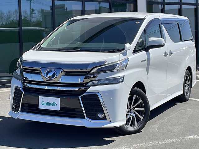 トヨタ ヴェルファイア ハイブリット ZR 道東・釧路十勝 2016(平28)年 10.3万km ホワイトパールクリスタルシャイン ・４WD/・アルパインビックX11型ナビ/【CD/DVD/フルセグ.BT.SD.FM/AM】/・アルパイン１２.８型フリップダウンモニター/・バックカメラ/・ETC/・両側パワースライドドア/・ハーフレザーシート/・パワーバックドア/・クルーズコントロール/・前席パワーシート/・LEDヘッドライト/・フォグライト/・横滑り防止/・本革巻きステアリング/・ステアリングスイッチ/・社外アルミ冬タイヤ積込/・純正エンジンスターター/・コーナーセンサー/・ユピテルレーダー/・保証書・取説