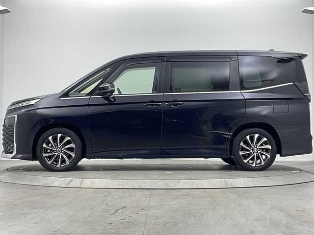 トヨタ ヴォクシー ハイブリッド S－Z 大阪府 2022(令4)年 1.4万km グリッターブラックガラスフレーク 純正10.5incディスプレイオーディオナビ/【フルセグTV/Bluetooth/HDMI/FM/AM/USB】/快適利便パッケージ(High)/・両側ハンズフリーパワースライドドア/・パワーバックドア/・前後シートヒーター/・ステアリングヒーター/・後席オットマン/・nanoe/3眼LEDヘッドライト/ブラインドスポットモニター/AC100Vコンセント/トヨタセーフティセンス/・レーダークルーズコントロール/・プリクラッシュセーフティー/・パーキングサポートブレーキ/・レーンディパーチャーアラート/・オートマチックハイビーム/・ロードサインアシスト/・ドライバー異常対応システム/オートホールド/前後コーナーセンサー/半革シート/後席サンシェード/ISOFIX