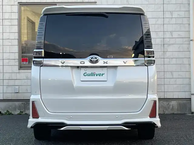 トヨタ ヴォクシー ZS 煌Ⅲ 福岡県 2021(令3)年 5.3万km ホワイトパールクリスタルシャイン 7人乗り/モデリスタエアロ【フロント・リア】/純正12.1インチフリップダウンモニター/純正リモートスターター(スマートキー一体型)×１/黒ハーフレザーシート/純正１０インチSDナビ【NSZN-Z68T】/(HDMI/AM/FM/Bluetooth/CD/DVD/フルセグTV】/バックカメラ/ビルトインETC/オートライト/Toyota Safety Sense/・PCS(プリクラッシュセーフティ)/・LDA(レーンディパーチャーアラート)/・オートマチックハイビーム/・先行車発進告知機能/PKSB(パーキングサポートブレーキ)/クルーズコントロール/クリアランスソナー/コーナーセンサー/アイドリングストップ/盗難防止装置/横滑り防止機能/社外前後ドライブレコーダーCOMTEC【DC-DR652】/USB充電ソケット/電格ウィンカーミラー/プッシュスタート/純正フロアマット/純正１６インチアルミホイール/ステアリングスイッチ/ISOFIX/フロントフォグランプ/ドアバイザー/ドラレコ取扱説明書/取扱説明書/保証書