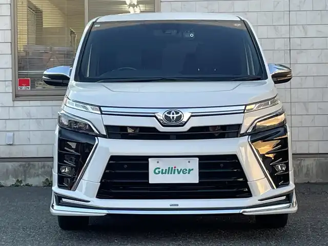 トヨタ ヴォクシー ZS 煌Ⅲ 福岡県 2021(令3)年 5.3万km ホワイトパールクリスタルシャイン 7人乗り/モデリスタエアロ【フロント・リア】/純正12.1インチフリップダウンモニター/純正リモートスターター(スマートキー一体型)×１/黒ハーフレザーシート/純正１０インチSDナビ【NSZN-Z68T】/(HDMI/AM/FM/Bluetooth/CD/DVD/フルセグTV】/バックカメラ/ビルトインETC/オートライト/Toyota Safety Sense/・PCS(プリクラッシュセーフティ)/・LDA(レーンディパーチャーアラート)/・オートマチックハイビーム/・先行車発進告知機能/PKSB(パーキングサポートブレーキ)/クルーズコントロール/クリアランスソナー/コーナーセンサー/アイドリングストップ/盗難防止装置/横滑り防止機能/社外前後ドライブレコーダーCOMTEC【DC-DR652】/USB充電ソケット/電格ウィンカーミラー/プッシュスタート/純正フロアマット/純正１６インチアルミホイール/ステアリングスイッチ/ISOFIX/フロントフォグランプ/ドアバイザー/ドラレコ取扱説明書/取扱説明書/保証書