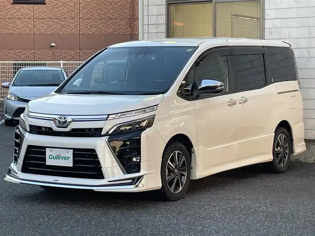 トヨタ ヴォクシー ZS 煌Ⅲ 福岡県 2021(令3)年 5.3万km ホワイトパールクリスタルシャイン 7人乗り/モデリスタエアロ【フロント・リア】/純正12.1インチフリップダウンモニター/純正リモートスターター(スマートキー一体型)×１/黒ハーフレザーシート/純正１０インチSDナビ【NSZN-Z68T】/(HDMI/AM/FM/Bluetooth/CD/DVD/フルセグTV】/バックカメラ/ビルトインETC/オートライト/Toyota Safety Sense/・PCS(プリクラッシュセーフティ)/・LDA(レーンディパーチャーアラート)/・オートマチックハイビーム/・先行車発進告知機能/PKSB(パーキングサポートブレーキ)/クルーズコントロール/クリアランスソナー/コーナーセンサー/アイドリングストップ/盗難防止装置/横滑り防止機能/社外前後ドライブレコーダーCOMTEC【DC-DR652】/USB充電ソケット/電格ウィンカーミラー/プッシュスタート/純正フロアマット/純正１６インチアルミホイール/ステアリングスイッチ/ISOFIX/フロントフォグランプ/ドアバイザー/ドラレコ取扱説明書/取扱説明書/保証書